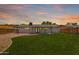 A sprawling backyard with lush lawn and a view of the home at dusk at 1058 E 2Nd St, Mesa, AZ 85203