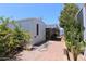 Mobile home featuring well maintained siding, a covered patio, and desert landscaping along a brick-lined walkway at 111 S Greenfield -- # 602, Mesa, AZ 85206