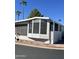 Charming mobile home with a screened-in porch, surrounded by desert landscaping and a quaint red rock border at 111 S Greenfield -- # 602, Mesa, AZ 85206