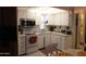 Efficient kitchen design with ample white cabinets, microwave, and stove, complemented by a view of dining area at 111 S Greenfield -- # 602, Mesa, AZ 85206