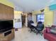 Open-concept living space with yellow walls featuring a dining area and a cozy seating area with a TV at 111 S Greenfield -- # 602, Mesa, AZ 85206