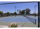 This image shows a tennis court with white lines and a green and blue surface, viewed through a chain-link fence at 111 S Greenfield -- # 602, Mesa, AZ 85206
