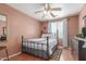 Bedroom with ceiling fan and a metal bed frame, complemented by a colorful patterned rug at 1149 N Sunnyvale Ave, Gilbert, AZ 85234