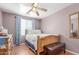 Bedroom with wooden bed frame, ceiling fan, and lots of natural light from the window at 1149 N Sunnyvale Ave, Gilbert, AZ 85234