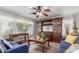 Cozy living room featuring a ceiling fan, a TV entertainment center, and two comfortable sofas at 1149 N Sunnyvale Ave, Gilbert, AZ 85234