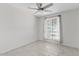Cozy bedroom featuring a ceiling fan, window and neutral tile flooring at 1160 E Hampton Cir, Mesa, AZ 85204