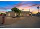Exterior view of a tan single-story home with desert landscaping and a long concrete driveway at 1160 E Hampton Cir, Mesa, AZ 85204