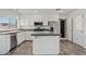 Well-lit kitchen featuring stainless steel appliances, white cabinetry, and a center island at 1160 E Hampton Cir, Mesa, AZ 85204