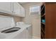 Functional laundry room with white cabinets and shelving at 1160 E Hampton Cir, Mesa, AZ 85204