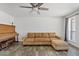 Comfortable living room with tile floors, a tan sofa, piano and a ceiling fan at 1160 E Hampton Cir, Mesa, AZ 85204