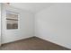 Minimalist bedroom featuring plush brown carpet, white walls, and a window with a view of the outdoors at 1373 S Vista Ave, Florence, AZ 85132