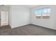 Cozy bedroom with plush gray carpet, white walls, a window, and a glimpse into an adjoining room at 1373 S Vista Ave, Florence, AZ 85132