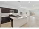 Open kitchen area with stainless steel appliances, island with sink, and tile flooring adjacent to living area at 1373 S Vista Ave, Florence, AZ 85132