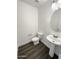 Charming half-bath with a pedestal sink and wood-look flooring at 1400 S Crossbow Ct, Chandler, AZ 85286