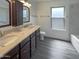 Bathroom with double vanity, granite countertops, framed mirror, and shower-tub combo at 1400 S Crossbow Ct, Chandler, AZ 85286