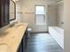 Bathroom with double vanity, granite countertops, framed mirror, and shower-tub combo at 1400 S Crossbow Ct, Chandler, AZ 85286
