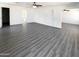 Large bedroom featuring gray wood-look floors, modern ceiling fan, and multiple entry doors at 1400 S Crossbow Ct, Chandler, AZ 85286