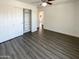 Bedroom with gray wood-look floors and closet with open bi-fold doors at 1400 S Crossbow Ct, Chandler, AZ 85286