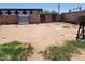 Spacious backyard, dirt and overgrown grass, with a metal shed and gated entrance at 1602 N 57Th Ave, Phoenix, AZ 85035