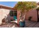 Landscaped backyard showcasing hardscape, patio furniture, potted tree and air conditioning unit at 16818 S 23Rd St, Phoenix, AZ 85048