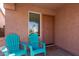 Cozy front porch featuring two blue adirondack chairs and a 'Home Sweet Home' door mat at 16818 S 23Rd St, Phoenix, AZ 85048