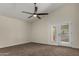 Large primary bedroom with ceiling fan, neutral carpet, and French doors at 18610 N 45Th Ave, Glendale, AZ 85308