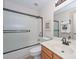 Bathroom showcasing tub with glass enclosure, a toilet and a vanity at 19120 N 98Th Ln, Peoria, AZ 85382