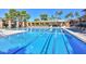 Large community pool with lane markers, surrounded by lounge chairs and shaded areas for relaxation at 19120 N 98Th Ln, Peoria, AZ 85382