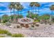 Beautifully landscaped clock in the community with colorful flowers and palm trees at 19120 N 98Th Ln, Peoria, AZ 85382