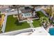 Aerial view of a backyard featuring a pergola-covered dining area, well-manicured artificial turf, and modern pavers at 1925 E Lane Ave, Phoenix, AZ 85020