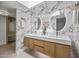 Bathroom featuring a double sink vanity, marble wall, and illuminated mirrors at 1925 E Lane Ave, Phoenix, AZ 85020