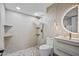 Modern bathroom featuring a stylish, round mirror, walk-in shower with gold fixtures and custom tile work at 1925 E Lane Ave, Phoenix, AZ 85020