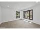 Empty room with tile floors and black framed windows offers natural light and a minimalist aesthetic at 1925 E Lane Ave, Phoenix, AZ 85020