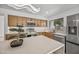 Stylish kitchen showcasing stainless steel appliances, light wood cabinets, and a unique light fixture above the island at 1925 E Lane Ave, Phoenix, AZ 85020