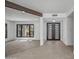 Open-concept living room featuring tile flooring, black-framed windows, and a striking wooden beam accent at 1925 E Lane Ave, Phoenix, AZ 85020