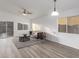 Bright living room featuring vinyl floors, white walls, a ceiling fan, and glass patio doors at 1952 N 103Rd Dr, Avondale, AZ 85392