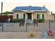 Charming bungalow-style home featuring solar panels, a cozy porch, and a wrought-iron fence at 2014 N 17Th Pl, Phoenix, AZ 85006