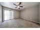 Bright, carpeted bedroom featuring a ceiling fan and a sliding glass door to the exterior at 2025 E Campbell Ave # 137, Phoenix, AZ 85016