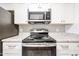 Close up of a stainless steel electric range with white cabinets and granite countertops at 2025 E Campbell Ave # 137, Phoenix, AZ 85016