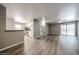 Open living room with wood flooring, neutral walls, kitchen, and sliding glass door at 2025 E Campbell Ave # 137, Phoenix, AZ 85016