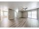 Open living room with wood flooring, neutral walls, ceiling fan, and sliding glass door at 2025 E Campbell Ave # 137, Phoenix, AZ 85016