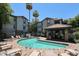 Community pool surrounded by lounge chairs, with lush landscaping and palm trees on a sunny day at 2025 E Campbell Ave # 137, Phoenix, AZ 85016