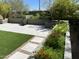 Inviting backyard featuring artificial grass, stone pavers, and flower beds brimming with colorful blooms at 21105 N 37Th Run, Phoenix, AZ 85050