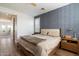 Bedroom with a large bed, blue accent wall, and window with wood shutters at 21105 N 37Th Run, Phoenix, AZ 85050