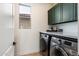Convenient laundry room featuring modern appliances and ample cabinet space at 21105 N 37Th Run, Phoenix, AZ 85050
