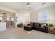Bright living room featuring a brown leather couch, neutral carpet, and natural light at 21105 N 37Th Run, Phoenix, AZ 85050