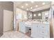 Bright bathroom featuring double sinks, elegant white cabinets, and a large mirror at 2129 E Beautiful Ln, Phoenix, AZ 85042