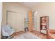 Cozy bedroom with hardwood floors, neutral walls, closet, and a comfortable chair at 2129 E Beautiful Ln, Phoenix, AZ 85042