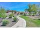 Beautifully landscaped walkway with lush greenery, bushes, mature trees, and residential homes in the background at 2129 E Beautiful Ln, Phoenix, AZ 85042