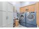 Well-equipped laundry room features modern washer and dryer, cabinets, and storage space at 2129 E Beautiful Ln, Phoenix, AZ 85042